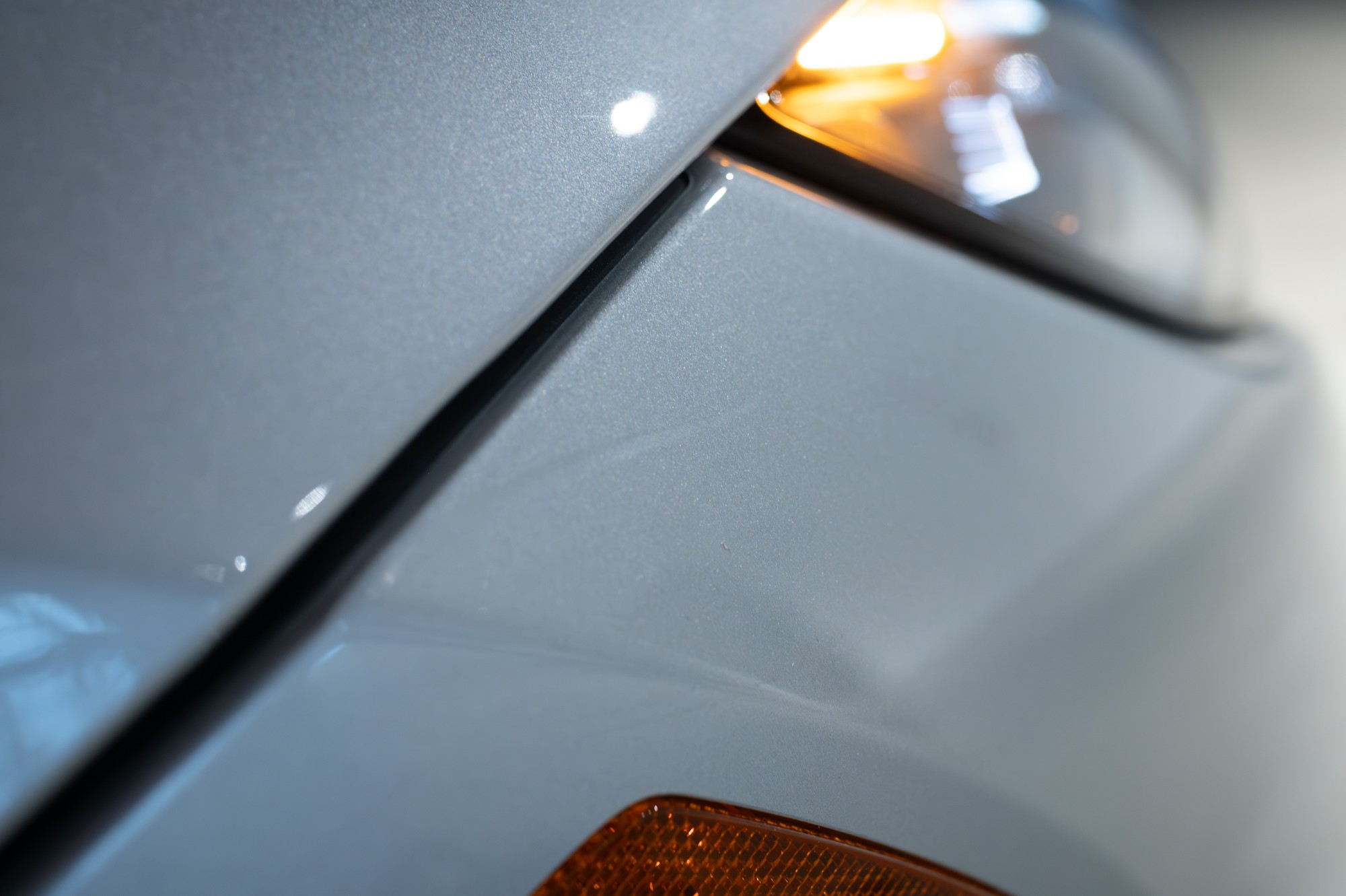 Light indentation in passenger side front bumper