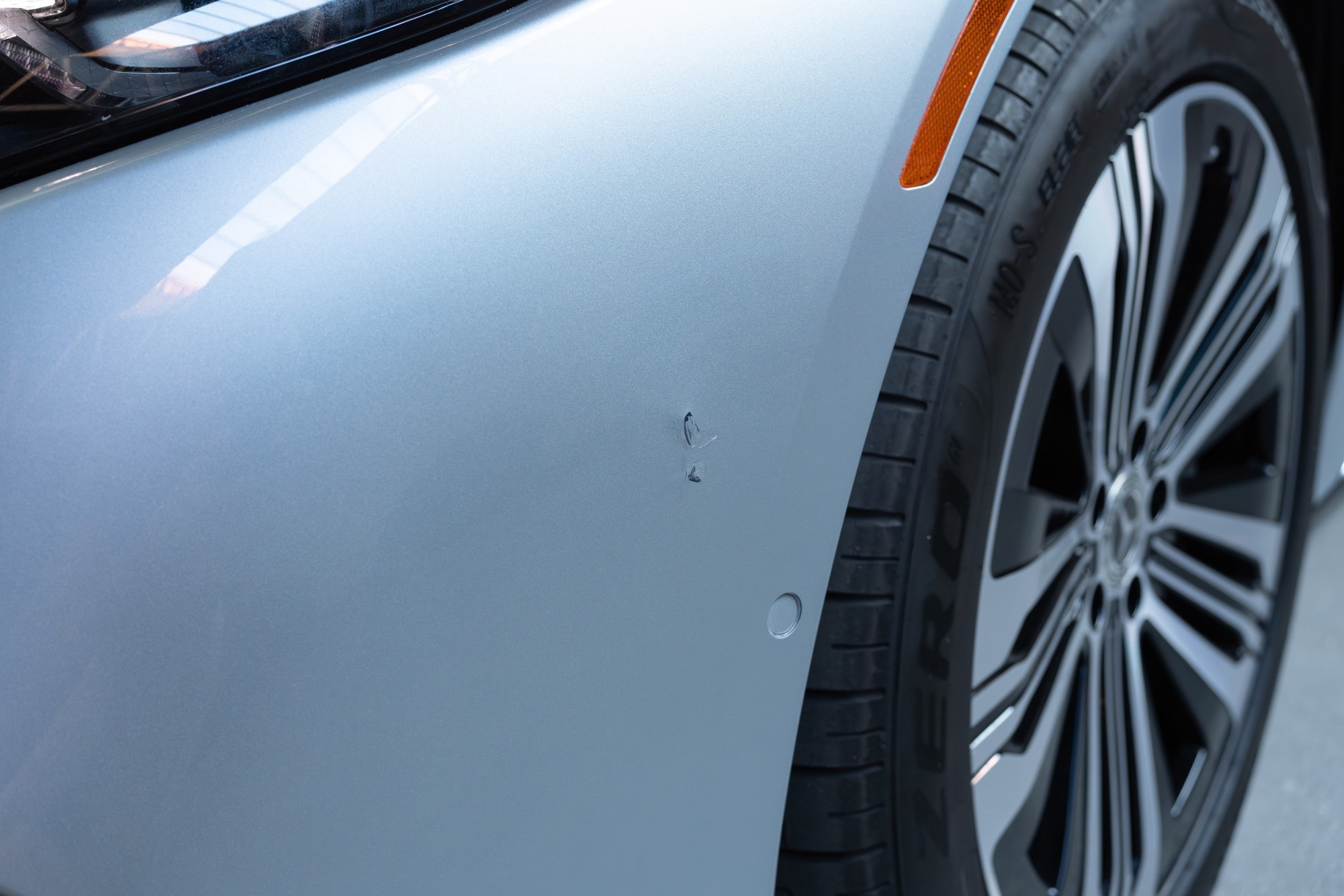 Touched up scrape on driver side front bumper