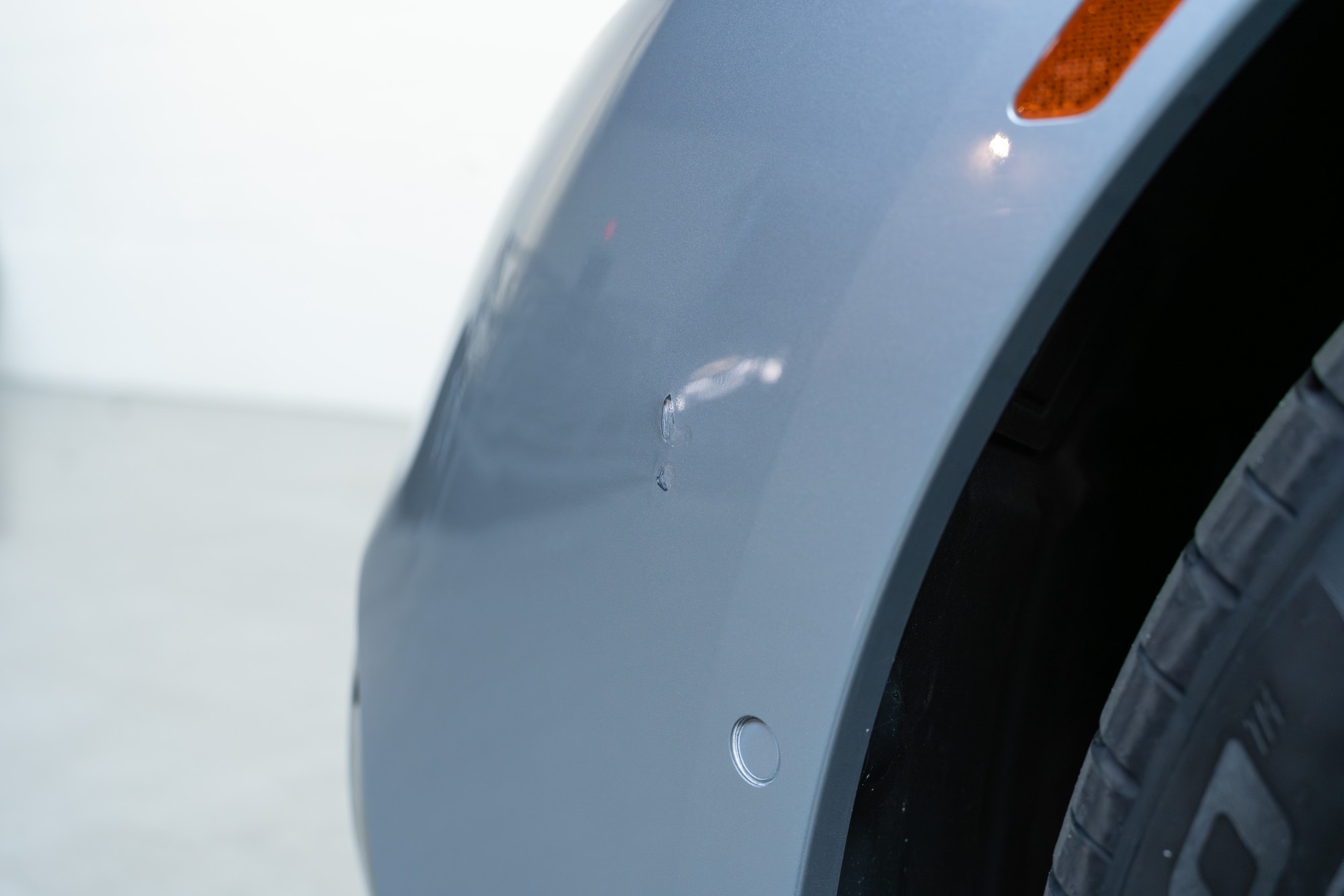 Touched up scrape on driver side front bumper